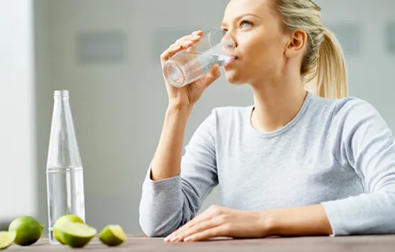 Mujer tomando agua con limón